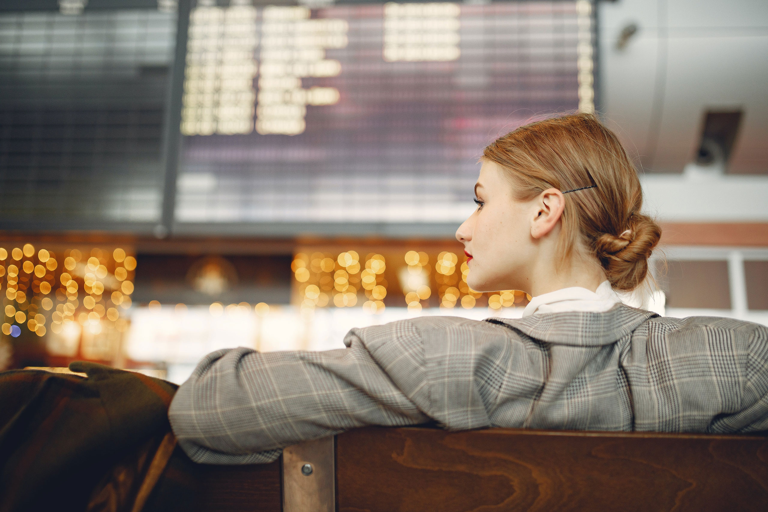 A woman, dressed in business attire, relaxing in an airport.